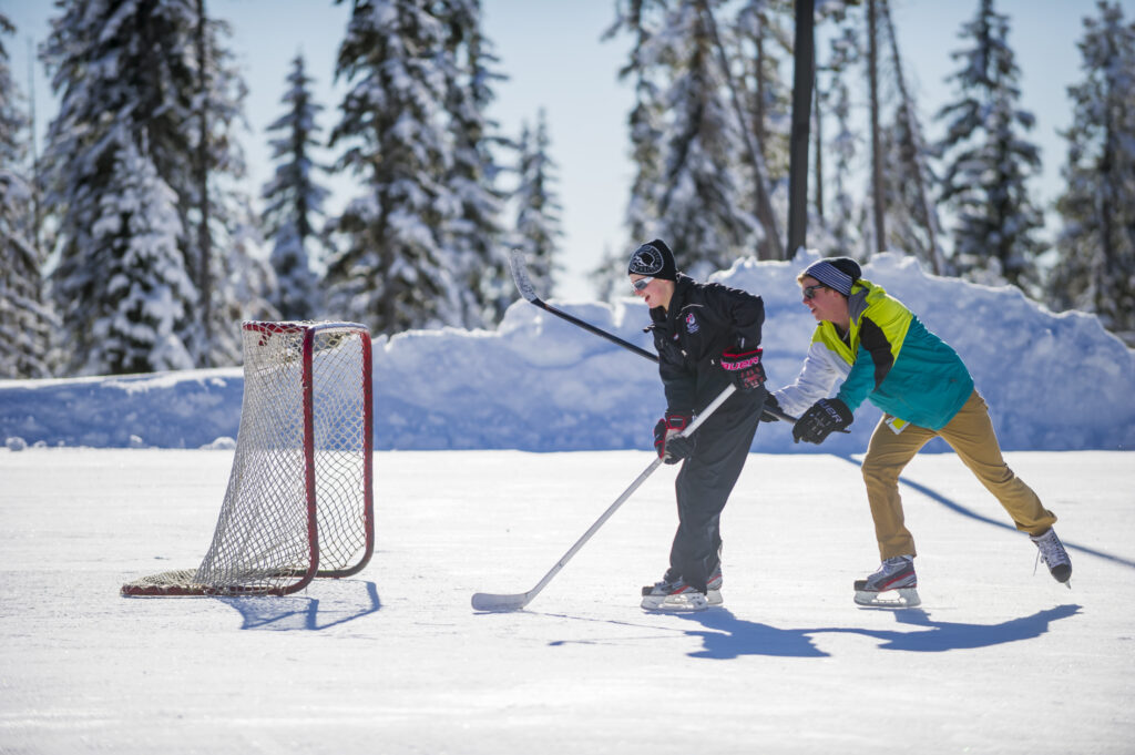 Kids having a leisurely skate and game of shinney on a sunny day at the ice rink at Biggy.
